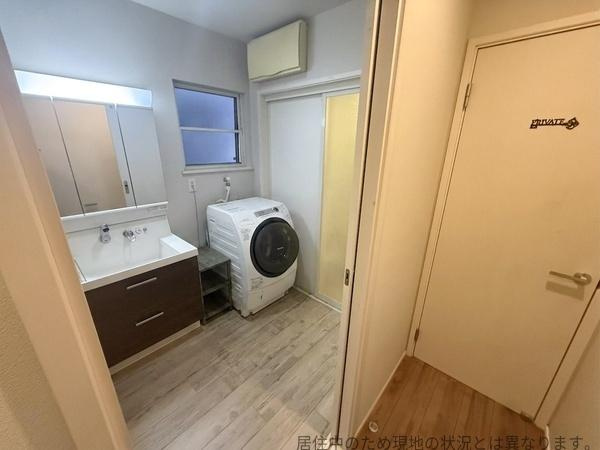 明磧2丁目　中古の独立洗面台|三面鏡付きの洗面化粧台があり収納スペースも充実しています。床は明るめの木目調で清潔感があります。浴室やトイレへの動線もスムーズです。
