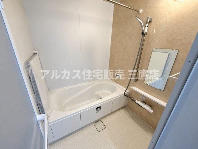 西武新宿線 花小金井駅 15分 新築戸建 小平市鈴木町1丁目の浴室|木目調のアクセントパネルが落ち着いた雰囲気を演出するバスルーム。ゆったりとした浴槽で一日の疲れを癒やせます。