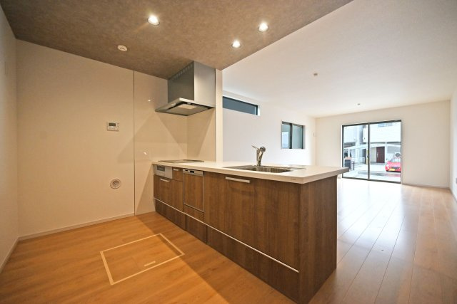 テラシエ食満3丁目新築一戸建て│4LDK+駐車並列2台可のキッチン|1階LDKをキッチン越しに撮影した現地内観写真です。 広くて使いやすいキッチンは折り下げ天井を採用しており、 オシャレな空間に仕上がりました。
