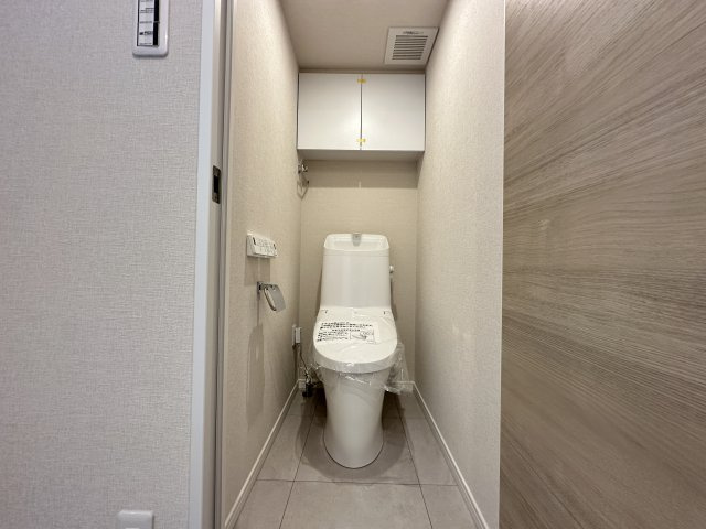 磯子センターハイツのトイレ|上部に吊戸棚があり、すっきりと使えそうな清潔感のあるトイレです。