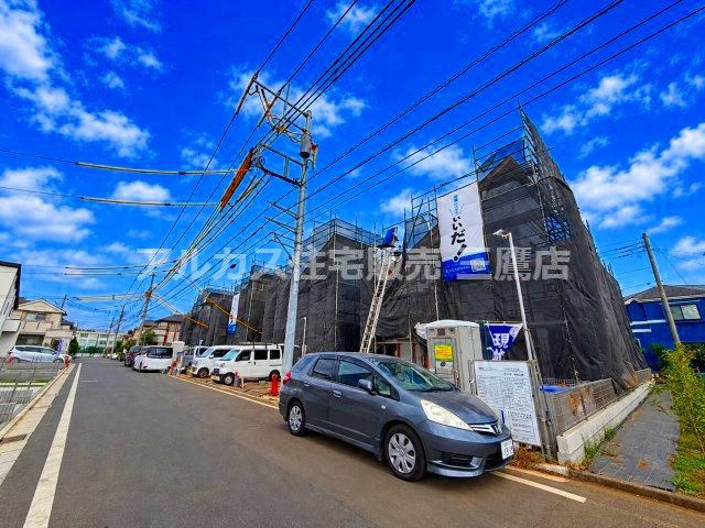 小平市鈴木町1丁目 西武新宿線 花小金井駅 売地の前面道路含む現地写真|黒の養生シートで覆われた建設中の建物外観。安全対策や近隣配慮が行き届いた現場で、職人による丁寧な施工が進められています。