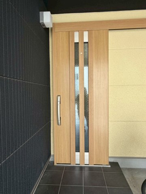 【玄関】 | 旭区今市１丁目中古戸建 | 中央に二本の採光ラインが並ぶ玄関ドア。シックな外壁と明るい木目の組み合わせがおしゃれです。