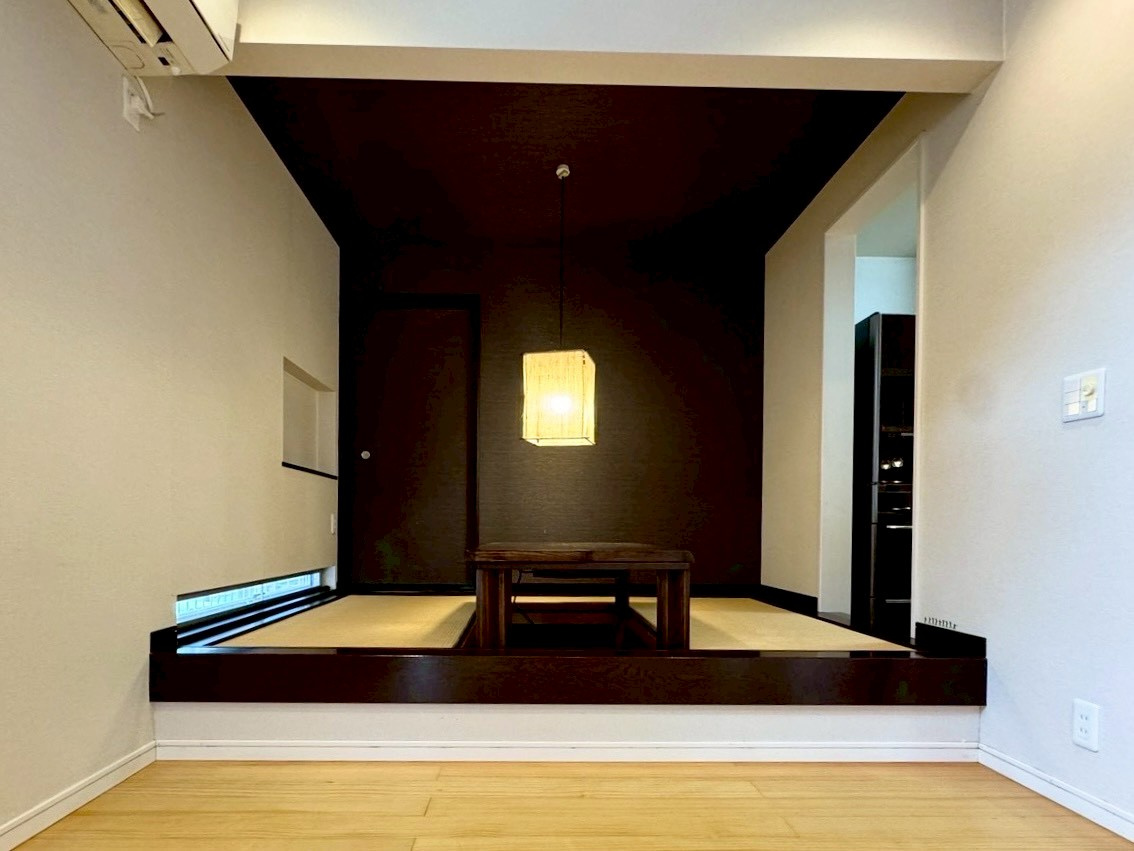 草津市追分南9丁目　中古戸建ての居間・リビング|キッチン横の小上がりスペースはほっと一息をつける落ち着く空間になっており、1日の疲れを癒す晩酌タイムにも最適ですね。