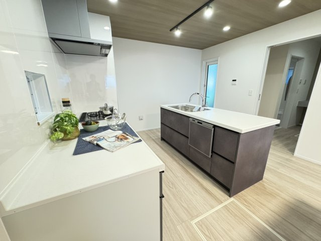 高尾通１丁目新築戸建のキッチン|シンプルなデザインと使いやすさを兼ね備えた対面式システムキッチンは、効率的な作業スペースを提供し、家族のコミュケーションを促進。