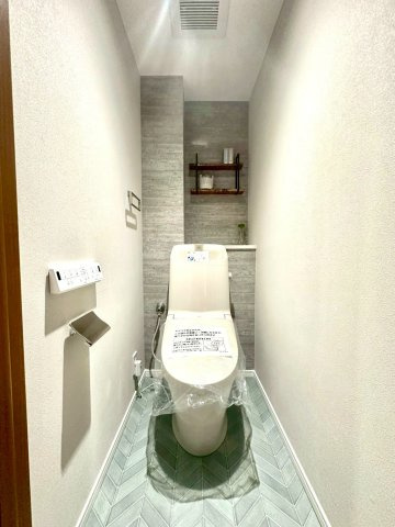 仲町台パークヒルズ五号棟のトイレ|清潔感ある空間にアクセントクロスを採用。コンパクトながらも上質さを感じる仕上がりです。