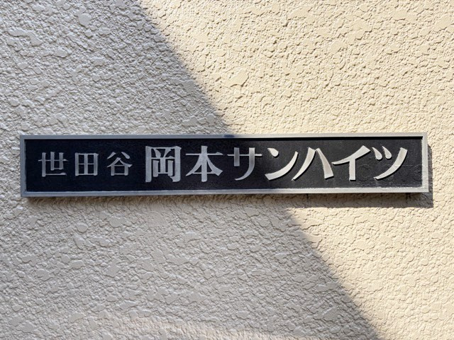 【現況写真】 | 岡本サンハイツ | エントランスに掲げられた、マンション名を示す館銘板。さほど激しく主張はしませんが、しっかりと掲示されています。～即日のご見学可能～　お問合せはお気軽にどうぞ。