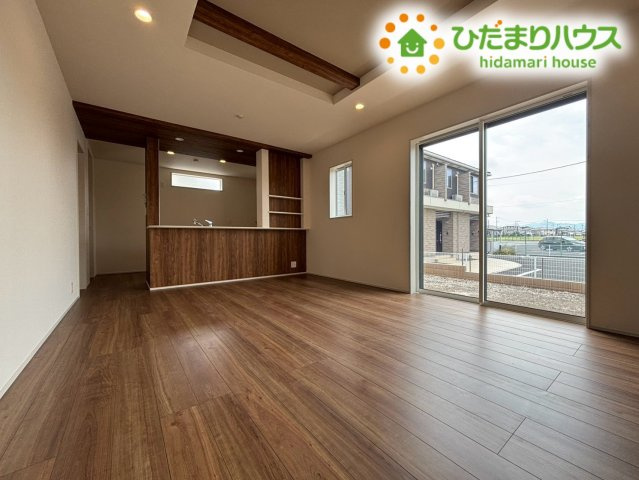 本庄市小島南1丁目　新築一戸建て　ブルーミングガーデン　01の居間・リビング|折上天井がおしゃれで開放感を演出する広々としたLDKです！大きな窓から明るい光と爽やかな風が通り抜けます！ご家族みんなが自然と集まり、ゆったりと笑顔でくつろげる心地よい空間ですよ♪