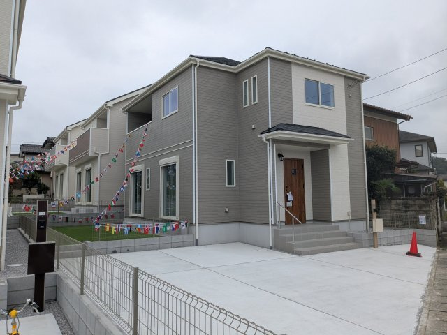新築戸建　片岡町の玄関|あたたかみのある木目調ドアが映える玄関ポーチ。手すりやポスト付きで快適に出入りできます。