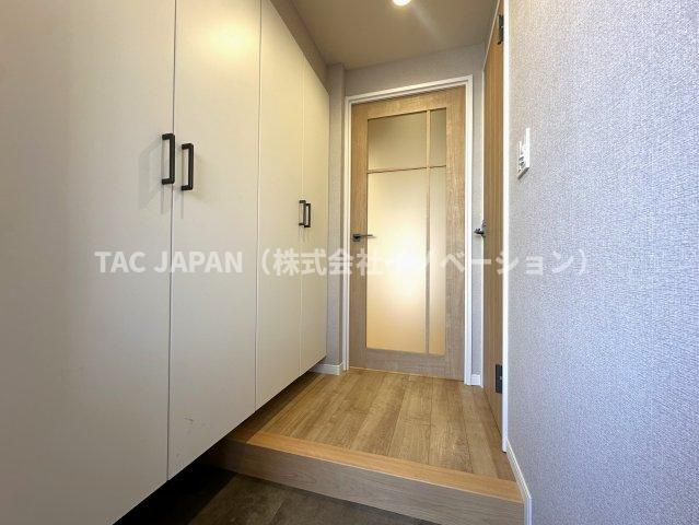 朝日江戸川橋マンションの玄関|日頃からスッキリ使いたい玄関スペースには天井まで届く大型シューズボックスを完備。人感センサー付き照明で明るく清潔感ある印象の素敵なお部屋に生まれ変わりました。
