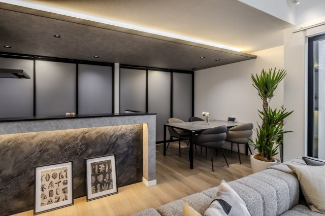 nattoku住宅　春日井モデルハウスのキッチン|落ち着いた色調と間接照明が印象的な、毎日の食事時間まで特別に感じられるダイニングキッチンです。