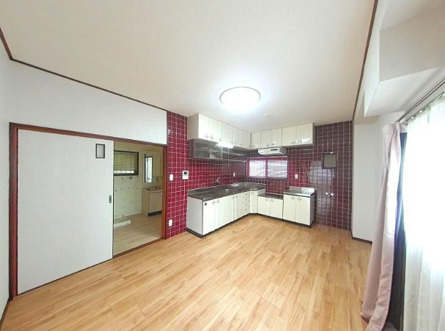高知市梅ノ辻　中古戸建てのキッチン|赤いタイルが印象的なキッチン空間。広々としたダイニングで、家族との時間をゆったり楽しめます。