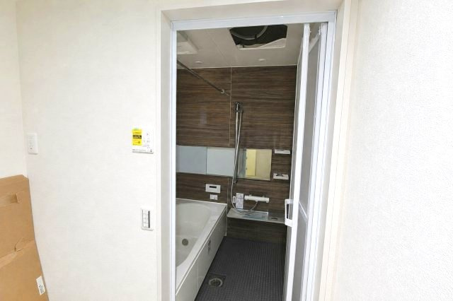 小金井市貫井南町3丁目 中央線 武蔵小金井駅 新築戸建の浴室|木目調アクセントパネルが上質な印象を演出。シャワーやミラー、カウンターを備えた使い勝手の良いバスルームです。
