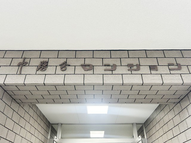 【現況写真】 | 中落合マンション | エントランスに掲げられた、マンション名を示す館銘板。さほど激しく主張はしませんが、しっかりと掲示されています。～即日のご見学可能～　お問合せはお気軽にどうぞ。