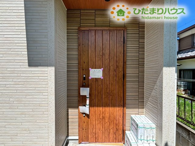 深谷市上柴町東5丁目　新築一戸建て　ブルーミングガーデン　01のエントランス|木目調のあたたかみのある玄関ドアが印象的なエントランスです！
深い庇が設置されているため、雨の日でも傘を落ち着いてさすことができ、鍵の出し入れやカバンの中身を探す際も濡れる心配がなくとても快適です◎