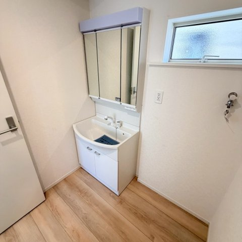 クレイドルガーデン松山市ひばりケ丘 第1の独立洗面台|清潔感のある洗面スペースは、朝の身支度もスムーズに整う設計。浴室乾燥機との連携で、脱衣所からすぐに洗濯物を干せる動線も魅力。毎日の家事が少しずつ楽になる、工夫された空間に。