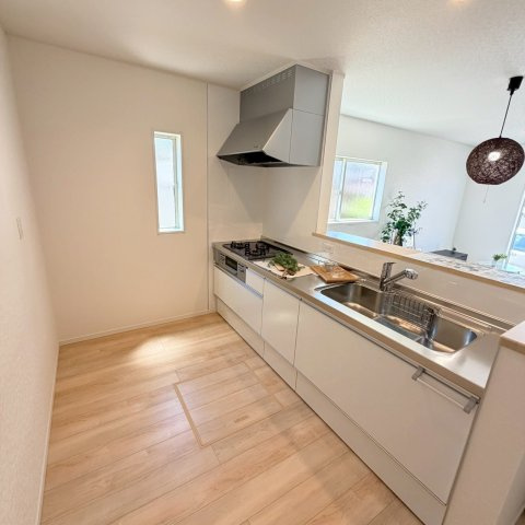 クレイドルガーデン松山市ひばりケ丘 第1のキッチン|対面式システムキッチンは浄水器付きで、お料理も捗るデザインに。リビングを見渡しながら作業ができるので、お子様の様子を見守りつつ、会話を楽しみながら美味しい食事の準備ができる。