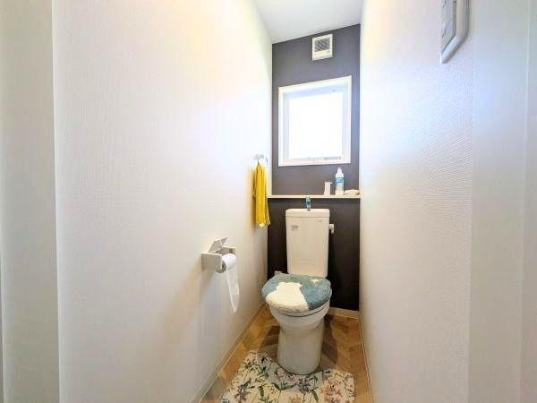 大字江無田　戸建てのトイレ|明るい光が差し込む空間で清潔感のあるトイレです。壁のアクセントカラーが印象的です。収納スペースも備わっています。シンプルで使いやすいデザインです。