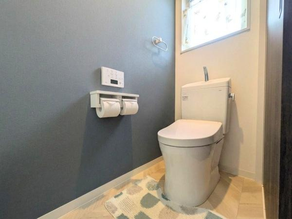 大字江無田　戸建てのトイレ|落ち着いた色合いの壁が印象的なトイレです。小窓から自然光が入り明るさを感じられます。ダブルペーパーホルダーが設置されていて便利です。シンプルな内装で清潔感があります。
