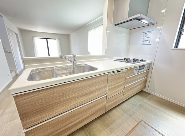 【キッチン】 | 志木市柏町1丁目　新築一戸建住宅　全2棟　(丸井志木店) | 人造大理石トップが上質な空間を演出。毎日のお手入れもしやすく、快適なキッチンライフを叶えます。
奥まで見渡せるスライド収納は調理器具や食器を出し入れしやすく、毎日の家事を快適にサポートします。
