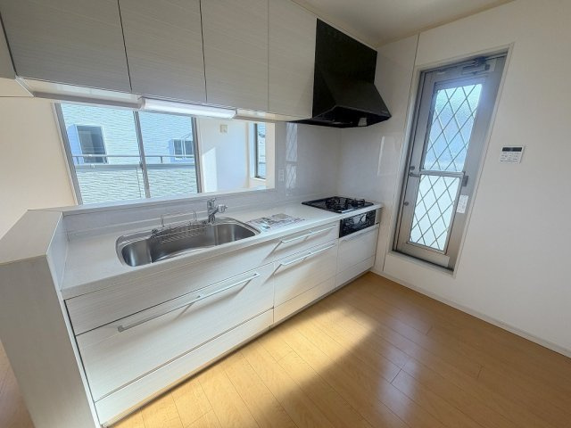 吉川市中曽根1丁目　中古戸建のキッチン|会話の弾む対面システムキッチン。勝手口付きのキッチンです。