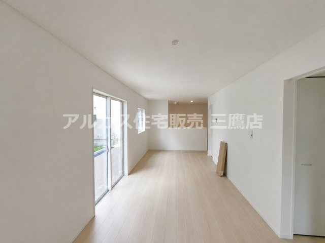 京王線 西調布駅 19分 新築戸建 調布市富士見町3丁目の居間・リビング|掃き出し窓と小窓を備え、対面キッチンへとつながる木目調のLDKです。