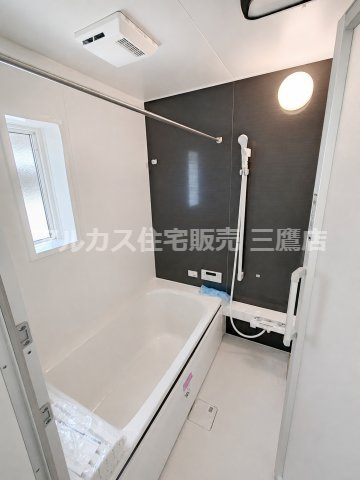 京王線 西調布駅 19分 新築戸建 調布市富士見町3丁目の浴室|ダークカラーの壁面が印象的な、窓と物干しバーを備えた浴室です。