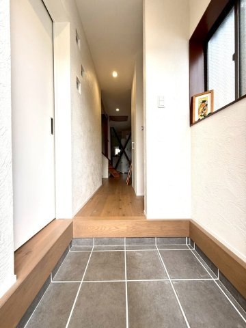 暮らしに寛ぎを生む小上がりリビング採用　東永谷三丁目中古戸建の玄関|木の温もりを感じる玄関空間。奥へと続く廊下が住まい全体に広がりと上質感を演出しています。