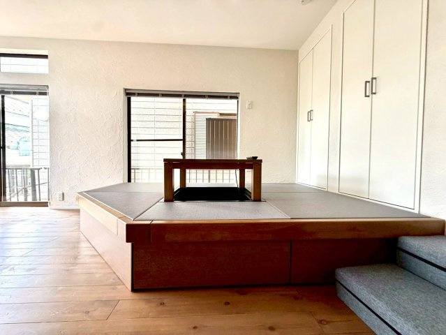 暮らしに寛ぎを生む小上がりリビング採用　東永谷三丁目中古戸建の居間・リビング|小上がりの畳スペースは、くつろぎや家族団らんに最適。収納付きで機能性にも優れています。