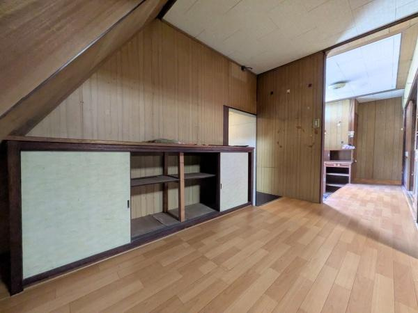 佐賀関　戸建ての収納|階段下スペースを活用した収納が設けられています。木目調の内装と調和したシンプルな扉が特徴で、廊下からすぐアクセスできて便利です。