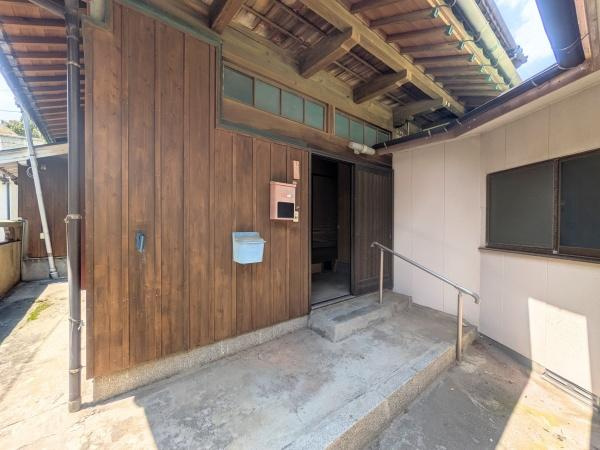 佐賀関　戸建ての玄関|木目調のドアが優しく迎えてくれる玄関です。手すり付きのアプローチは、家族みんなの『歩きやすさ』への思いやりが詰まっています。深いひさしのおかげで、雨の日でも慌てずゆっくり鍵を探せるのがうれしいですね。