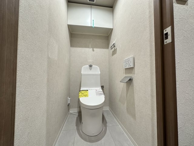 プライムコート磯子屛風ヶ浦のトイレ|温水洗浄便座のトイレ設備です！トイレ上部にはあると便利な吊戸棚を設置！