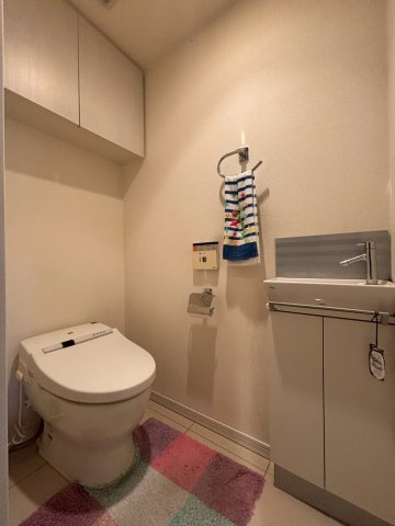白を基調とした清潔感のあるトイレスペース。手洗い場付で機能性を高め、お手入れもしやすいように床面はタイルを採用。