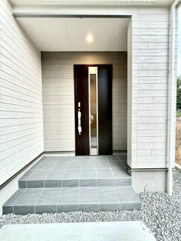 リーブルガーデンうるま市前原・9号棟の玄関|置き配スペースも確保できる屋根付きの玄関ポーチ／TVモニター付きインターフォンで防犯対策も◎