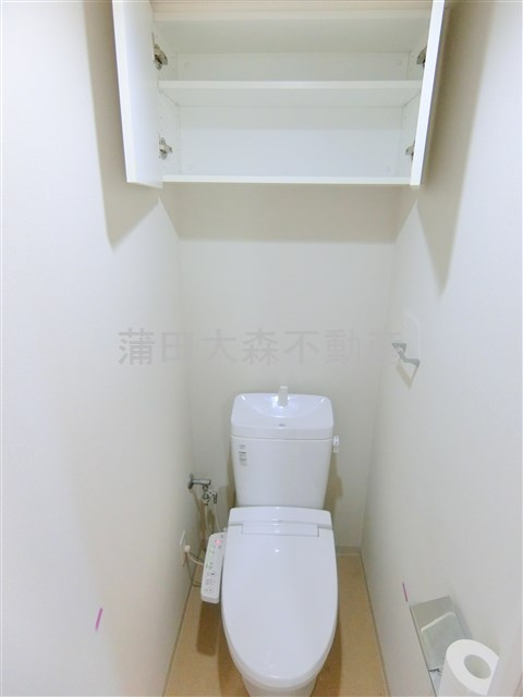 ラフィネジュ大森のトイレ|吊戸棚と温水洗浄便座付きのトイレ