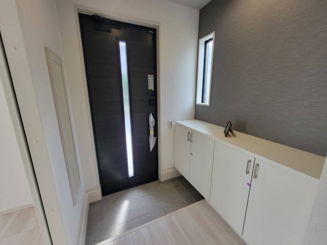 【LIGARE】真岡市熊倉町 第14期 全2棟の玄関|〇1号棟　玄関〇
シックなアクセントクロスがお洒落な印象です。玄関の視界が開け、開放的な印象を与えるロータイプのシューズボックスでご家族の靴もスッキリ収納します。
※2026年6月撮影