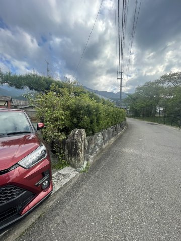 大生院　売土地の前面道路含む現地写真|前面道路は車の離合も可能な幅員が確保されており、毎日の車の出し入れもスムーズ。静かな環境で、落ち着いた暮らしが実現します。現地は平坦で開放感があり、日当たりも良いため明るい住まいの計画に適した環境。
