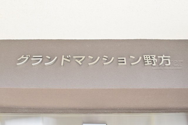 【現況写真】 | グランドマンション野方 | エントランスに掲げられた、マンション名を示す館銘板。さほど激しく主張はしませんが、しっかりと掲示されています。～即日のご見学可能～　お問合せはお気軽にどうぞ。
