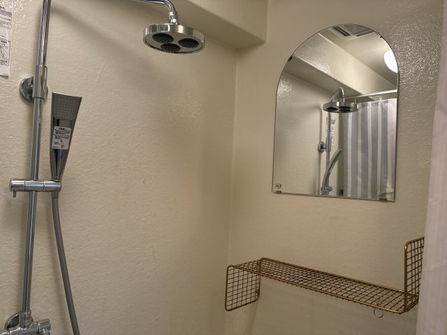 紅葉ガ丘ガーデンハイツA棟の浴室|トイレと同じ空間にあるシャワーブース、鏡と棚が付いています。