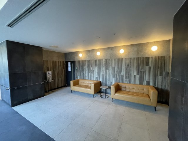 アルファステイツ宇宿のその他共用部分|エレベータ前にもソファーが備えられています。
