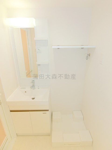 リヴシティ蒲田イーストの洗面所|洗面脱衣所　独立洗面台　棚付きの洗濯機置き場