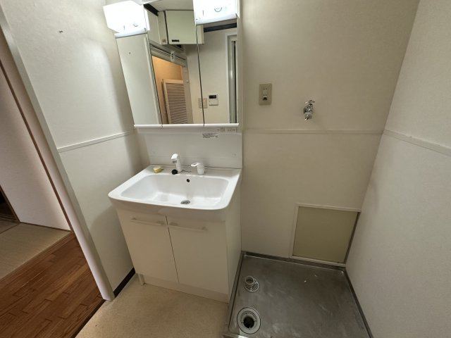 朝霧マンション　B棟の独立洗面台|【洗面台】化粧品や小物類などをすっきりと収納できる、三面鏡付きの洗面化粧台が備わっています。洗濯機用防水パンが設置されています。設置可能な洗濯機のサイズ等は現地でお確かめください。