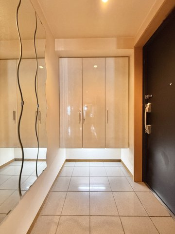 ブライトタウン上島A棟の玄関|大容量のシューズクロークと波状のルームミラーが、シンプルながらオシャレな空間を演出してくれています。
