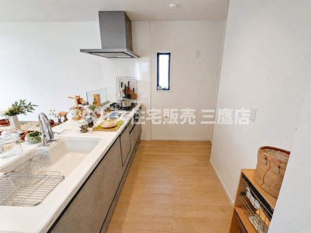 府中市幸町1丁目　京王線　府中駅　新築戸建のキッチン|スタイリッシュな対面式システムキッチン。スライド式収納やレンジフード、小窓を備え、作業スペースもゆとりを持たせた設計です。
