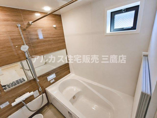 府中市幸町1丁目　京王線　府中駅　新築戸建の浴室|木目調のアクセントパネルがおしゃれなシステムバス。小窓からの採光・換気が可能で、ゆったりとした浴槽でリラックスできます。