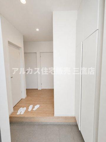 府中市幸町1丁目　京王線　府中駅　新築戸建の玄関|明るい木目調のフロアと白を基調とした壁面で清潔感のある玄関ホール。複数の扉を備え、各居室への動線がスムーズに確保されています。