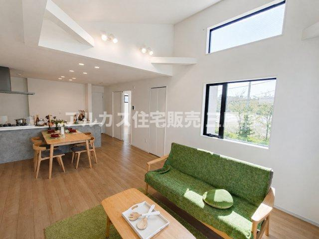 府中市幸町1丁目　京王線　府中駅　新築戸建の居間・リビング|リビングからキッチン方向を見渡した室内。勾配天井の立体感とダウンライトのあかりが、空間に広がりと深みをもたらします。