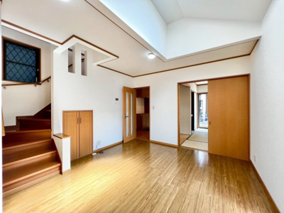 【居間・リビング】 | 磯上町　中古戸建 | リビングは天井が高く天窓トップライトのあるデザインです。リビング階段がある設計で家族団らんの空間になります。