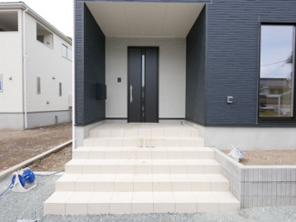 【玄関】 | 甲斐市中下条 新築全2棟 2号棟 敷地広々80坪・車並列3台 | 庇付きの玄関