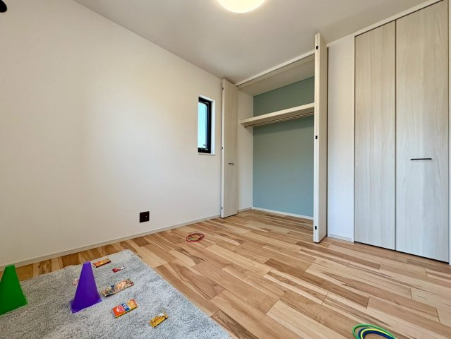 「サウナ付き分譲住宅」南国市大そね甲2号地　新築一戸建ての洋室|アクセントクロスが爽やかなお部屋。クローゼット完備で、おもちゃや衣類もすっきり片付きます。