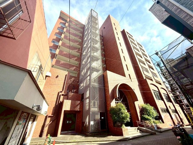 ドミール鶴見の外観|1980年9月に竣工したドミール鶴見は、南東・南西向きに住戸が配置され総戸数は56戸、DINKSやファミリー向けのマンションです。外観は10階建てのレンガタイル貼りで、1階にはスーパーが入っています。